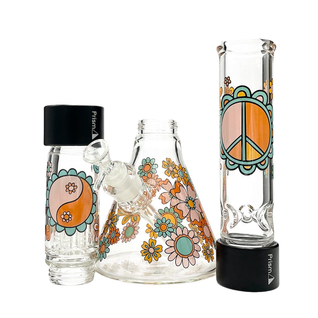 Front-facing view of the Prism Flower Power Beaker Double Stack showing three clear glass pieces decorated with orange, teal, and pink daisies and a peace sign on a white background.
