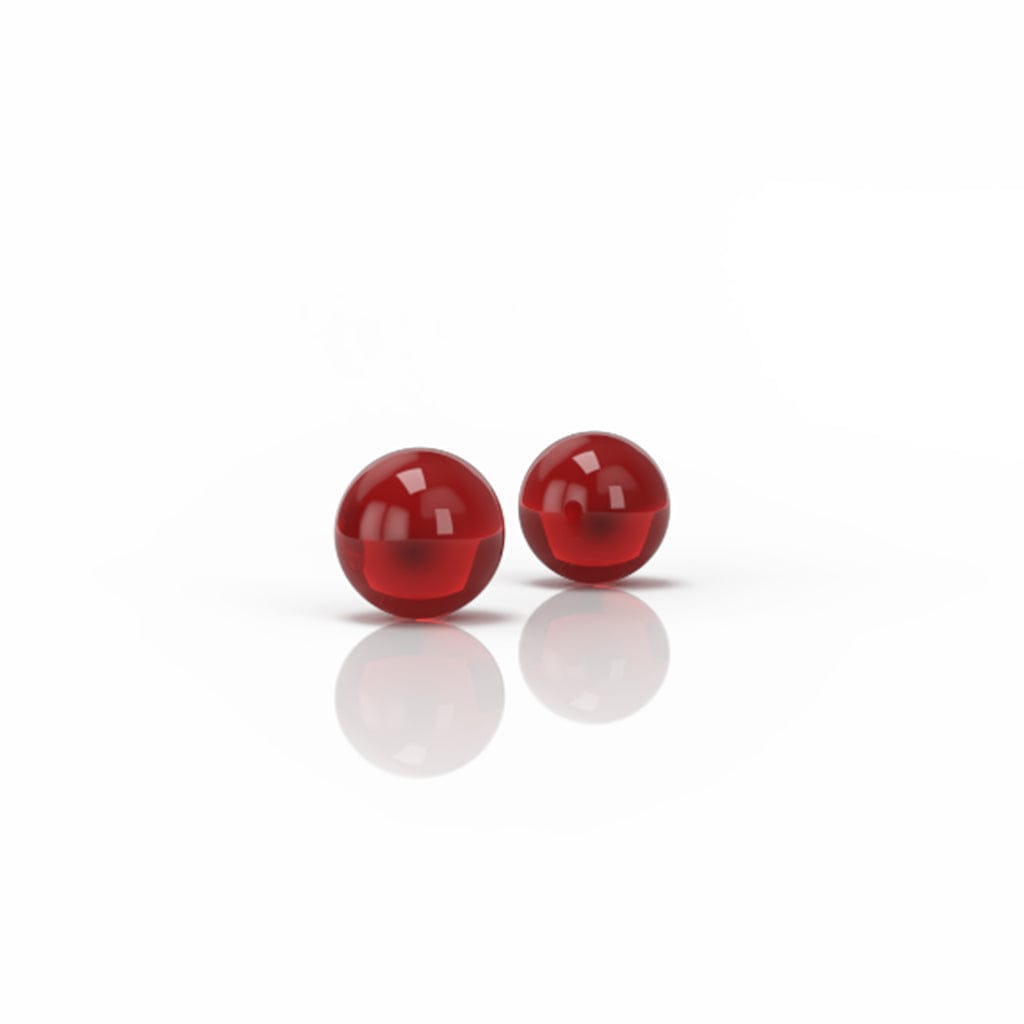 Two glossy red Honey Terp Pearls spheres photographed at slight angle on a white reflective surface, casting soft reflections.