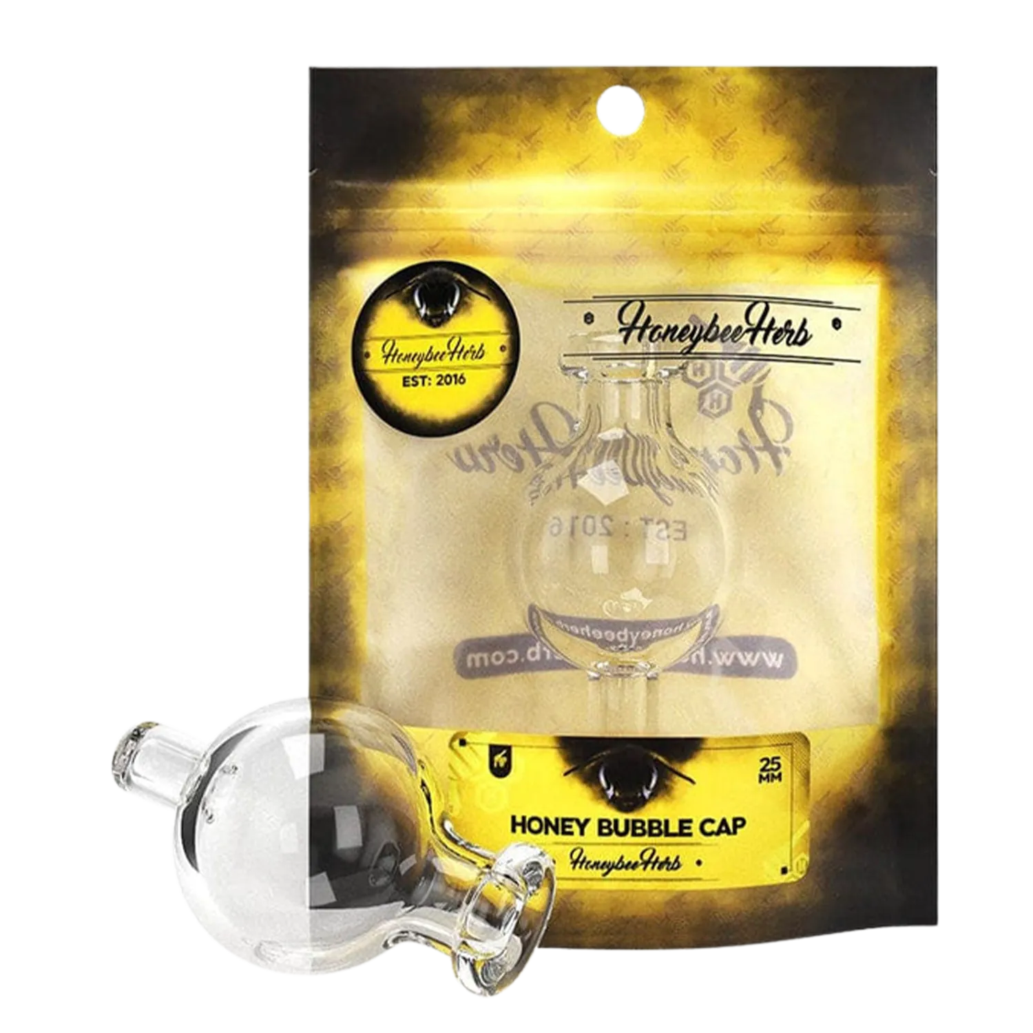 Angled close-up of a clear glass bubble carb cap resting against yellow‑black Honeybee Herb Honey Bubble Carb Cap packaging, showing its round bulb and short stem.