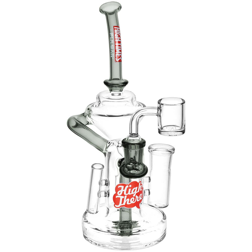 Angled studio shot of the High Times X Pulsar High There! All In One Recycler Dab Station - 8.25" / 14Mm F, clear glass with visible "High There" logo and upright recycler tubes.