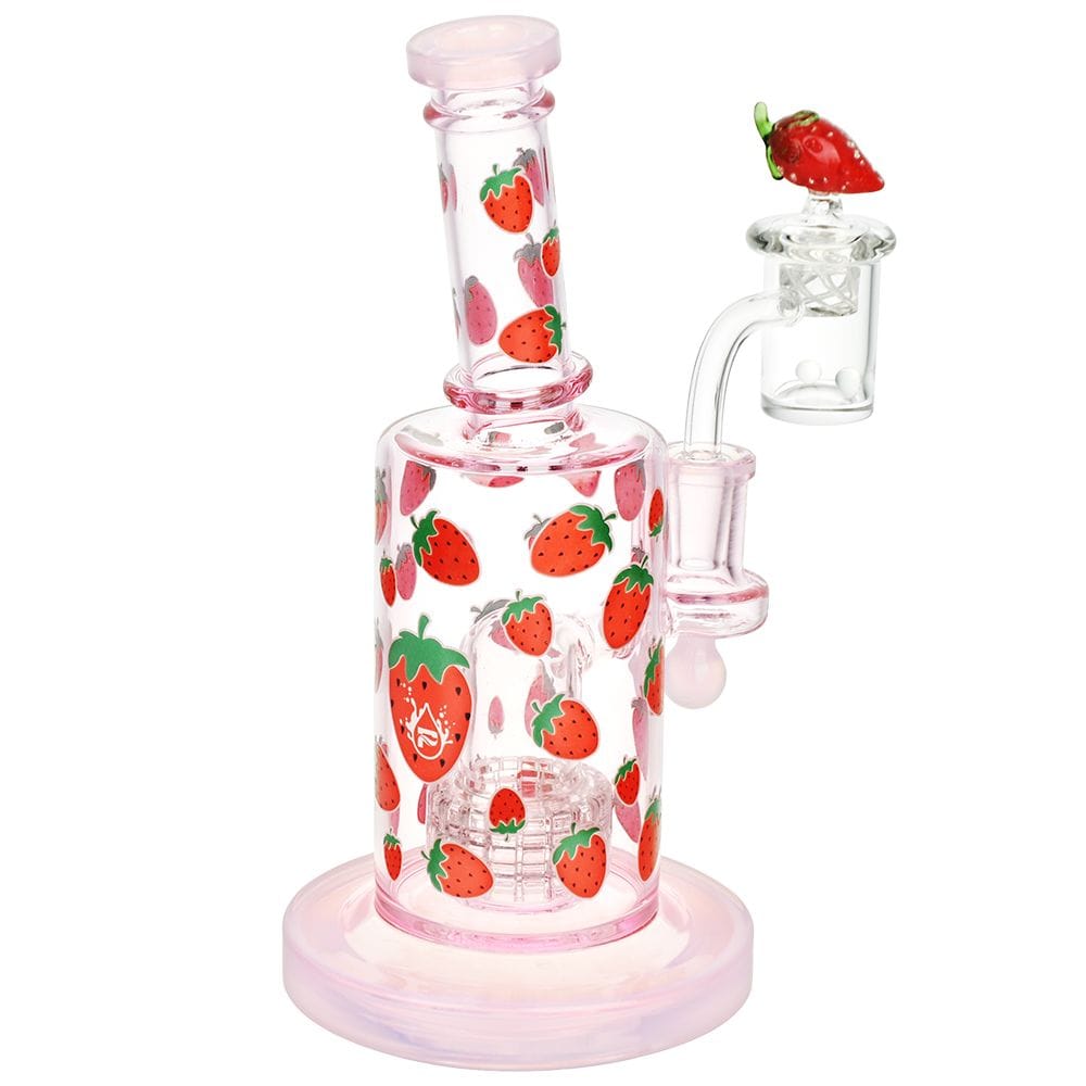 Three-quarter view of the Pulsar Fruit Series Strawberry Cough Glow In The Dark Dab Rig Kit - 8" / 14Mm F showing a pink-glazed glass rig covered with small strawberry decals and a matching strawberry-topped banger.