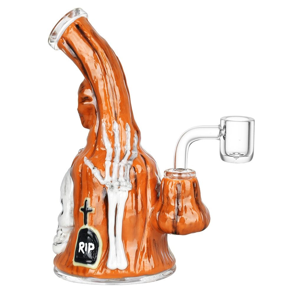 A three-quarter view of the Haunted Gourd Enamel on Glass Dab Rig, featuring orange glass with white enamel designs resembling a pumpkin.