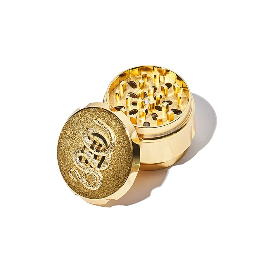 Top-down view of the Get Lit Kit, a gold grinder with visible inner components and textured side detailing.
