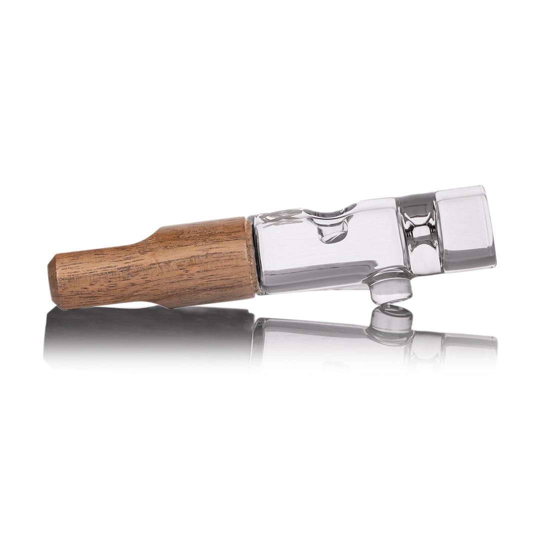 Side profile of the Alpine Series | Ridge Chillum Taster One Hitter showing a wooden mouthpiece joined to a clear glass body on a reflective white surface