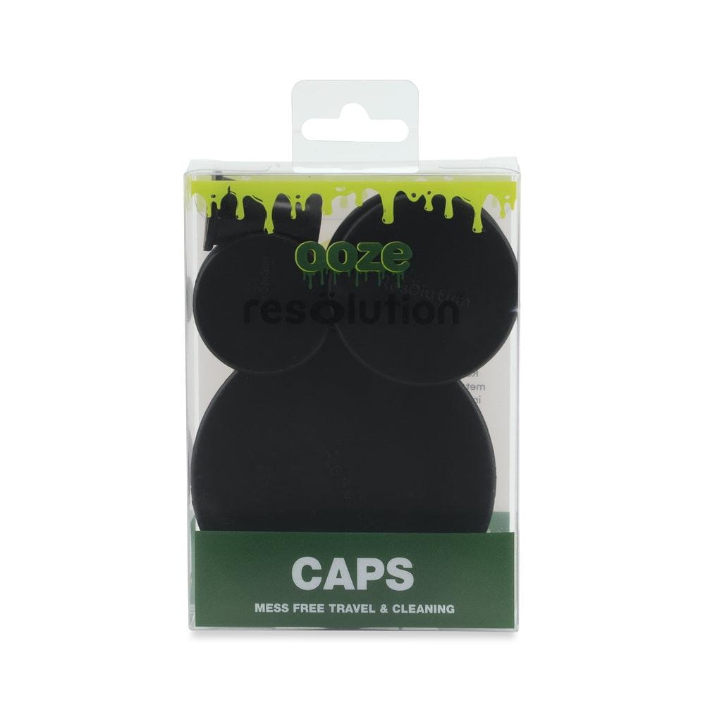 Front-facing shot of Ooze Resolution Caps in black arranged inside clear retail packaging with green drip graphics and a hang tab.