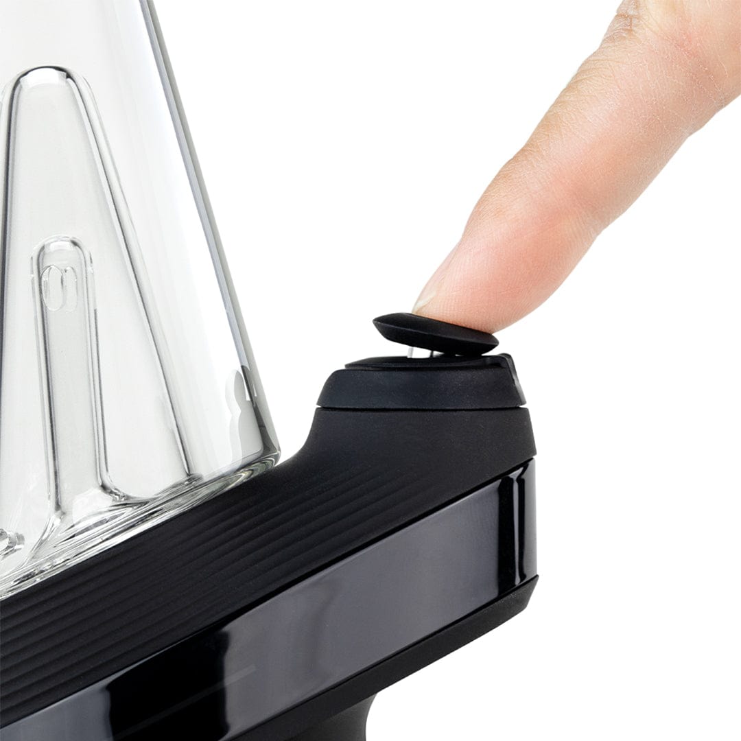 Close-up side shot of a finger pressing the black button on the Cloud Puffco New Peak Vaporizer, showing the glass cone and glossy black base.