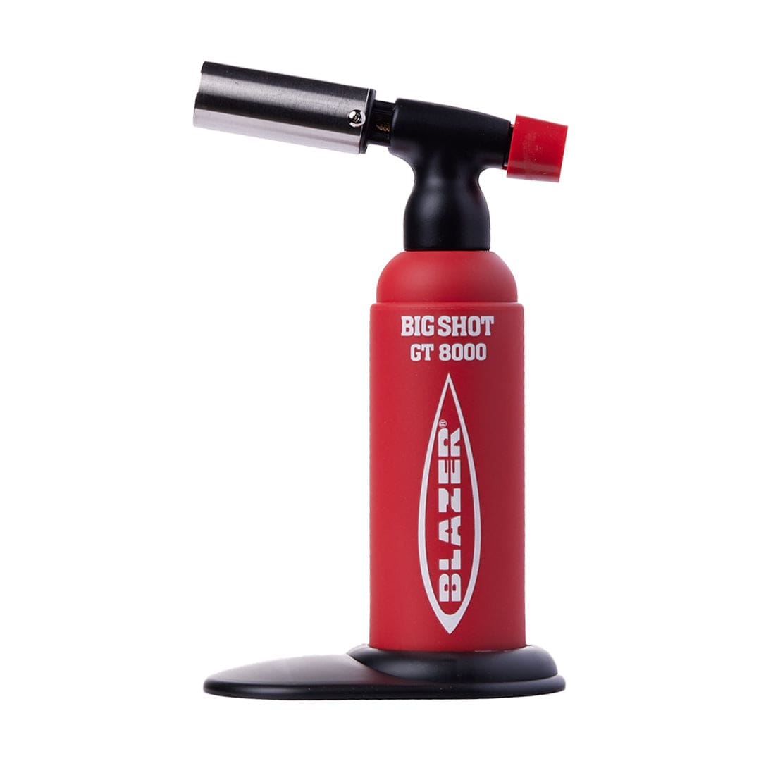 A close-up, angled view of the Big-Shot Torch GT 8000 with a black handle and silver nozzle, set against a dark background.