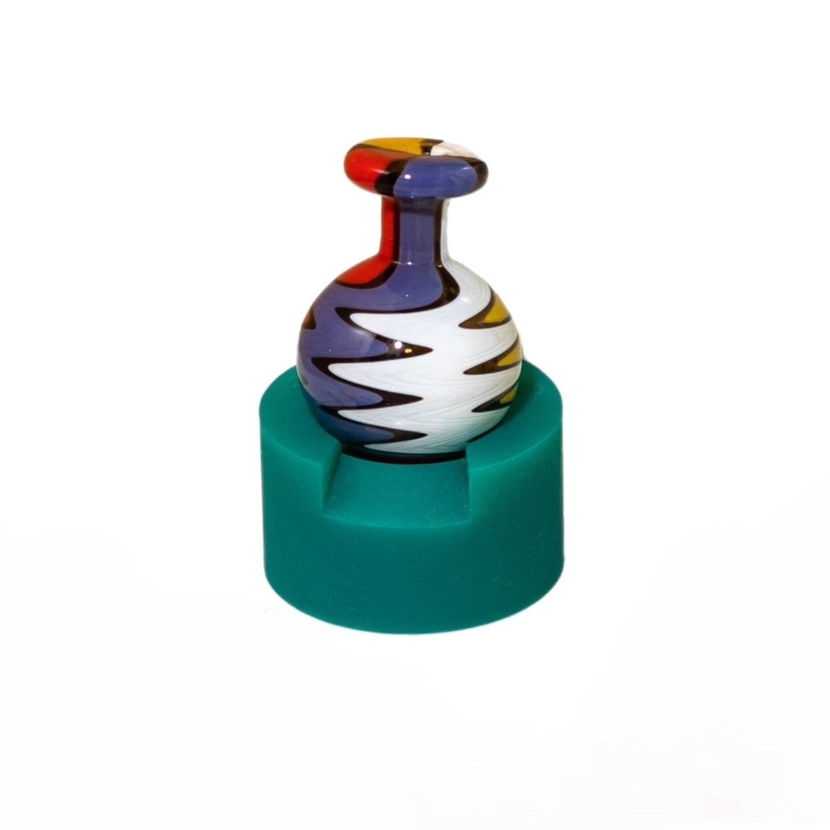 Front view of the V2 Carb Crib ® resting on a teal-colored pedestal, displaying a simple, cylindrical design.