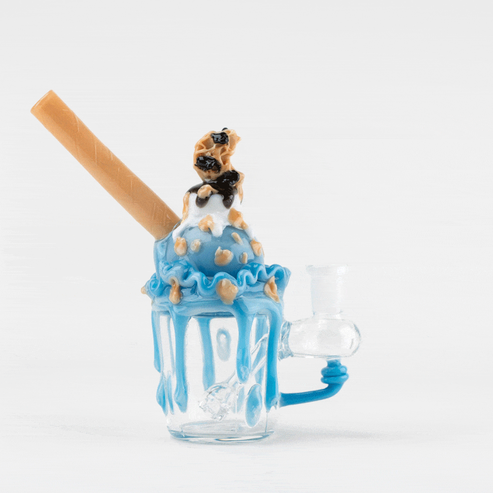 Front view of the Cookie Monster Sundae Nano Rig showing a clear glass body with blue dripping "frosting," a tan straw, and a small sundae topper.