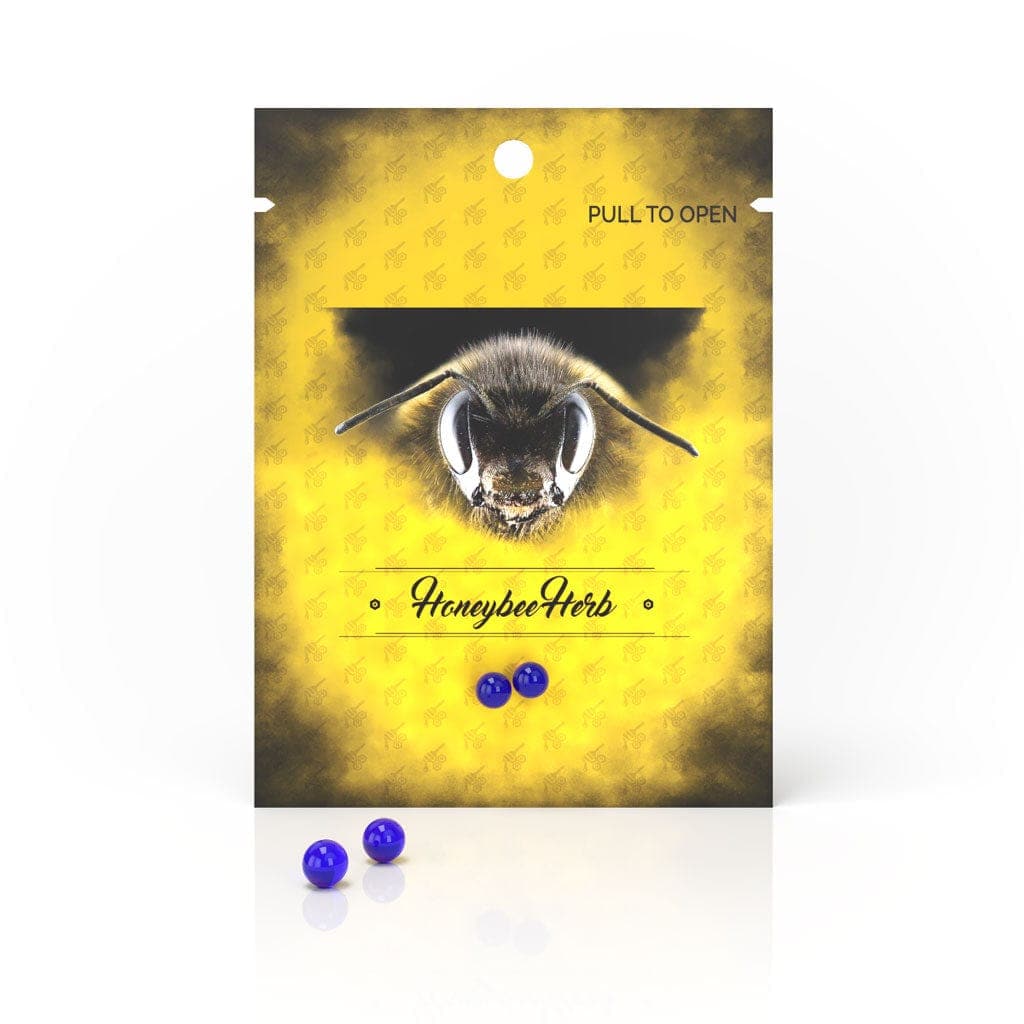 Front view of Honeybee Herb Honey Pearls in a clear plastic bag with a pull-to-open tab, displaying the small, round candies inside.
