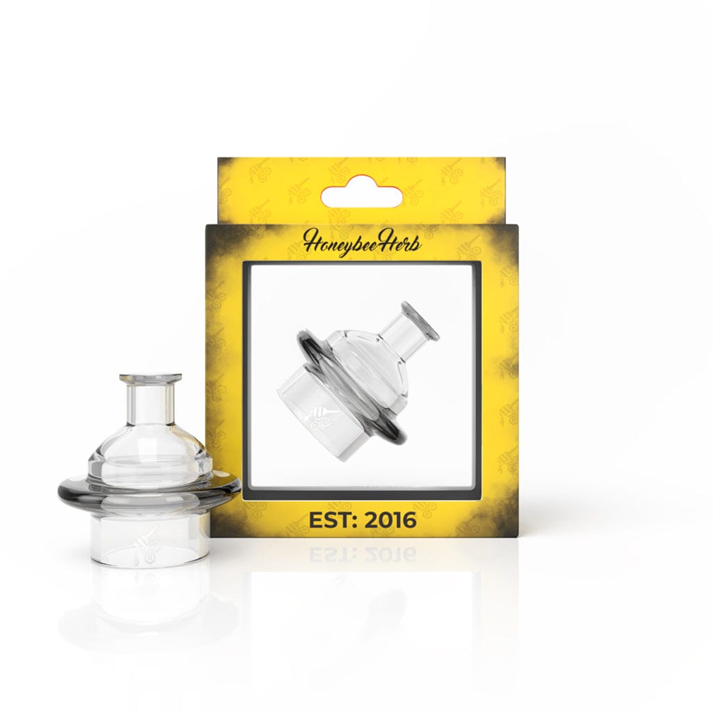 Front three-quarter view of a clear Honey Stax Carb Cap set beside its yellow HoneybeeHerb branded window box.