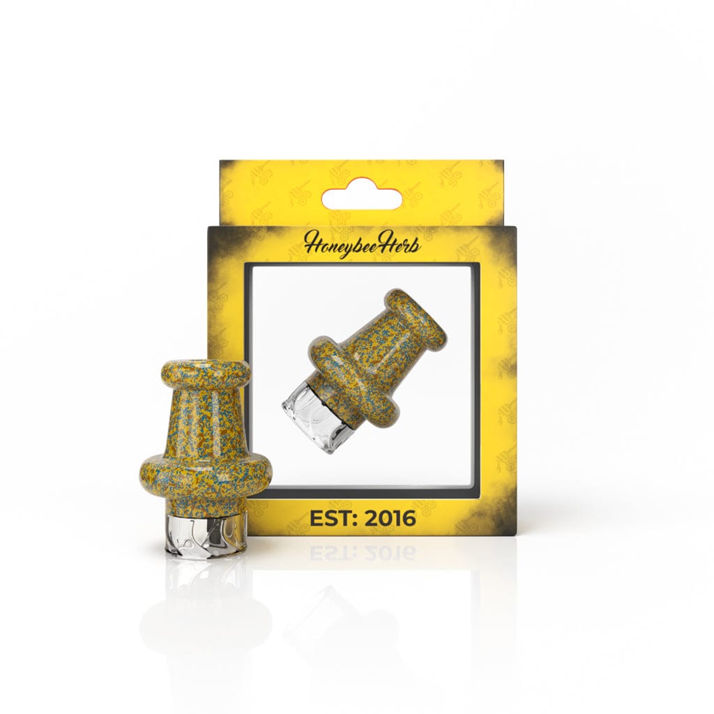 Front view of the blue RIPTIDE VORTEX CARB CAP shown standing beside its yellow display box with a reflected shadow on a white background